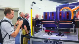 Pedestrian taking photo of RoboClip demo at Automate Show 2025